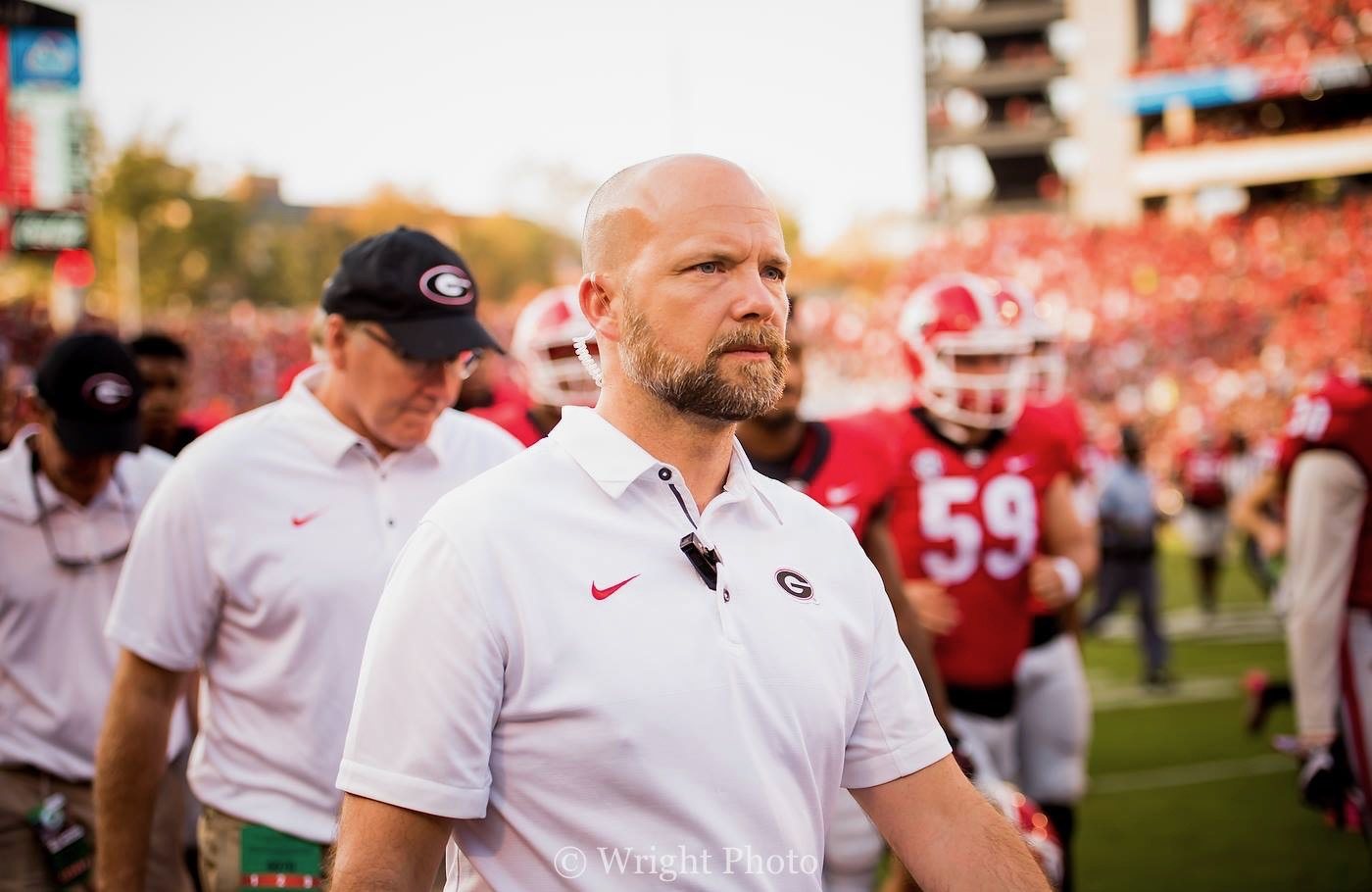 Kelly Ward on the Sanford Stadium sideline in Georgia gear, players in the background