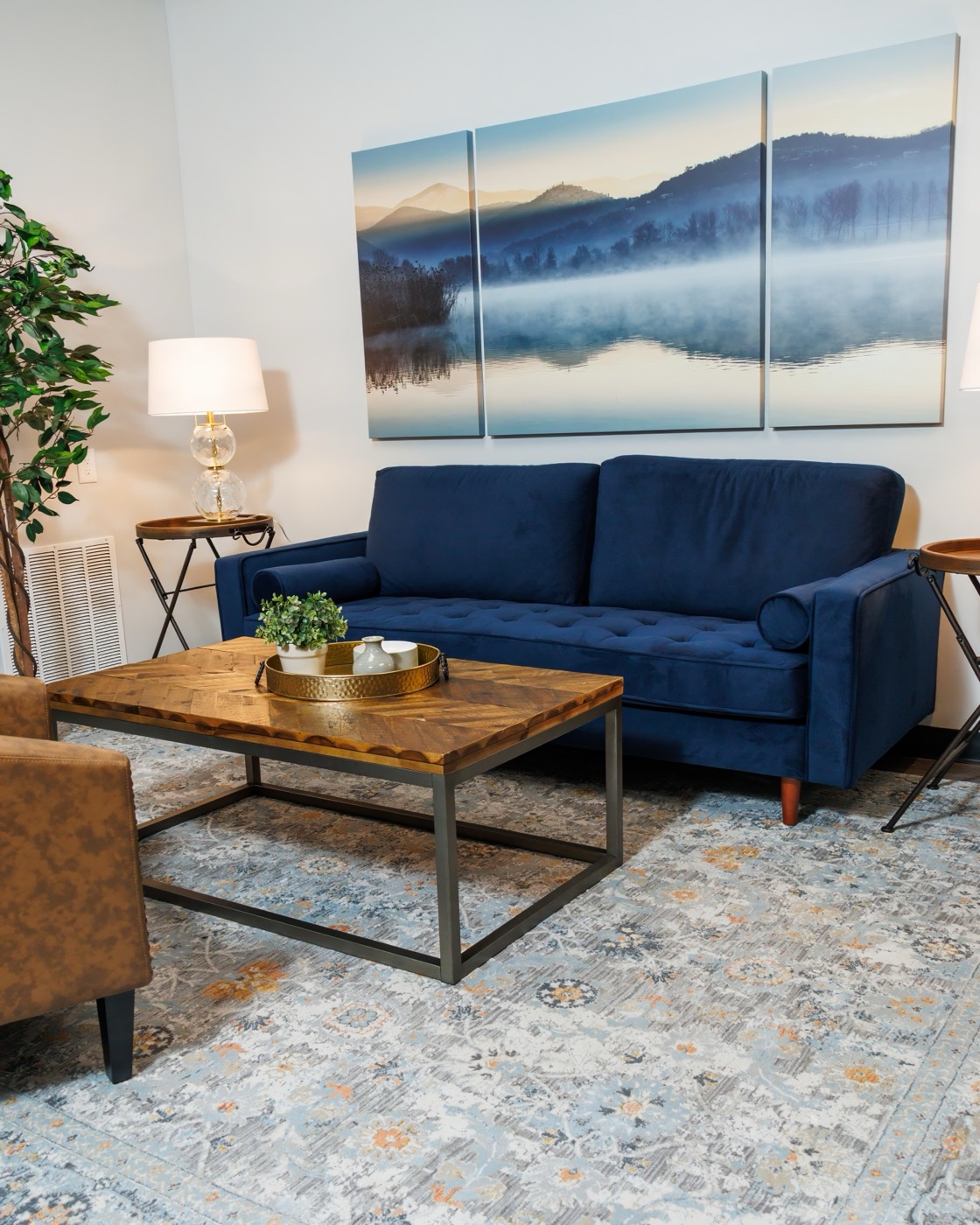 The FINISH lounge — a navy sofa and warm wood instead of a waiting room